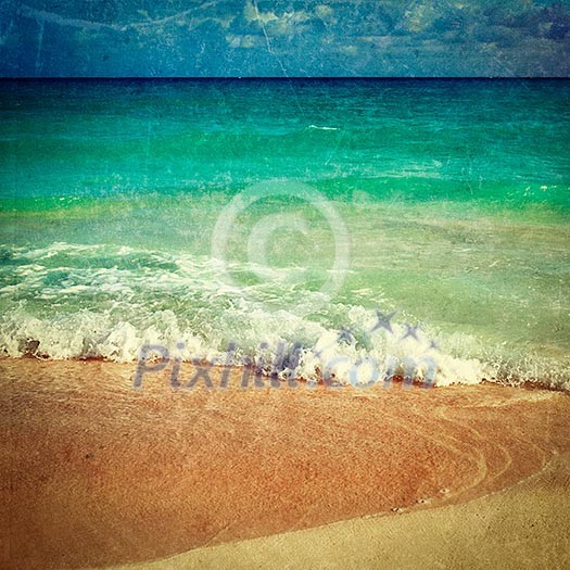 Vintage retro hipster style travel image of beautiful beach and  waves of Caribbean Sea with grunge texture overlaid