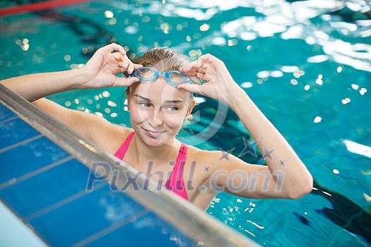 Female swimmer in an indoor swimming pool - doing crawl (shallow DOF)