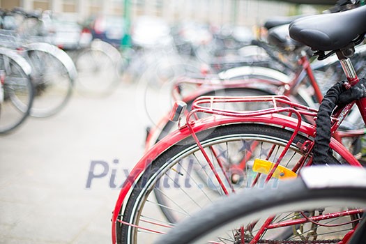 Bike rental service - Many bikes standing in bike stands, available for rent as a great mean of transport in the city Bike rental service - Many bikes standing in bike stands, available for rent as a great mean of transport in the city