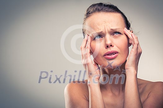 Gorgeous young woman with severe headache/migraine (color toned image)