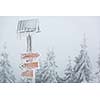 Extreme winter weather - hiking path sign covered with snow brought by strong wind during snowstorm