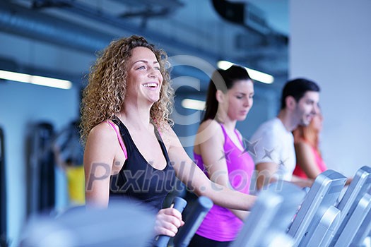 group of young people running on treadmills in modern sport gym group of young people running on treadmills in modern sport gym