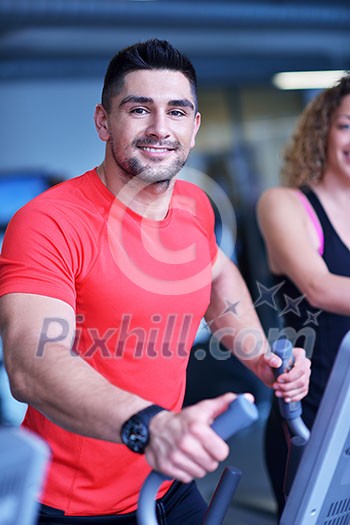 Handsome man running on the treadmill in modern gym