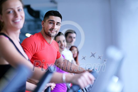 group of young people running on treadmills in modern sport gym group of young people running on treadmills in modern sport gym
