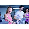 group of young people running on treadmills in modern sport  gym