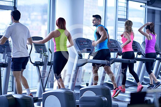 group of young people running on treadmills in modern sport  gym