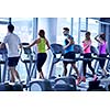 group of young people running on treadmills in modern sport  gym