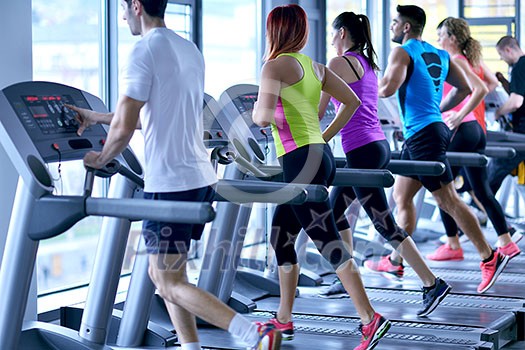 group of young people running on treadmills in modern sport  gym