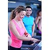 sport, fitness, lifestyle, technology and people concept - smiling woman exercising on treadmill in gym