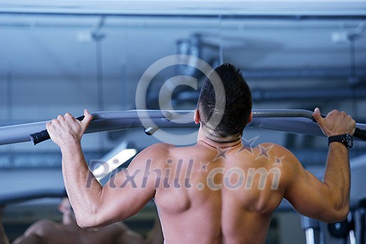 Strong handsome man exercising at the gym