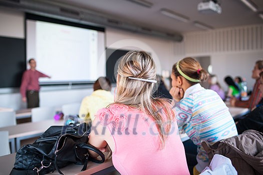 College students sitting in a classroom during class (shallow DOF; color toned image)