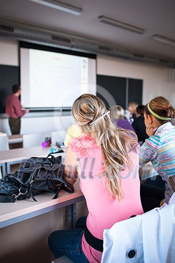 College students sitting in a classroom during class (shallow DOF; color toned image)