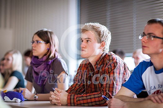 College students sitting in a classroom during class (shallow DOF; color toned image)