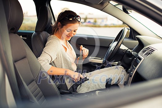 Pretty young woman driving her new car  (color toned image; shallow DOF)