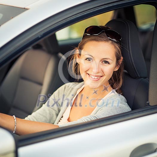 Pretty young woman driving her new car (color toned image; shallow DOF) Pretty young woman driving her new car (color toned image; shallow DOF)