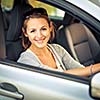 Pretty young woman driving her new car  (color toned image; shallow DOF)