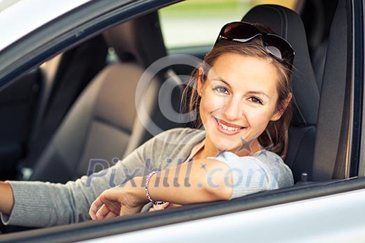 Pretty young woman driving her new car  (color toned image; shallow DOF)