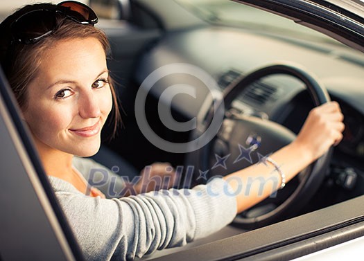 Pretty young woman driving her new car (color toned image; shallow DOF) Pretty young woman driving her new car (color toned image; shallow DOF)