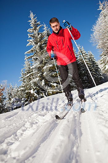 Cross-country skiing: young man cross-country skiing on a lovely sunny winter day