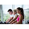 Beautiful group of young women friends  exercising on a treadmill at the bright modern gym