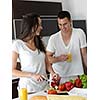 happy young couple have fun in modern kitchen indoor while preparing fresh fruits and vegetables food salad