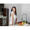 Young Woman Cooking in the kitchen. Healthy Food - Vegetable Salad. Diet. Dieting Concept. Healthy Lifestyle. Cooking At Home. Prepare Food