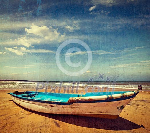 Vintage retro hipster style travel image of boat on a beach, India with grunge texture overlaid Vintage retro hipster style travel image of boat on a beach, India with grunge texture overlaid