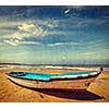 Vintage retro hipster style travel image of boat on a beach, India  with grunge texture overlaid