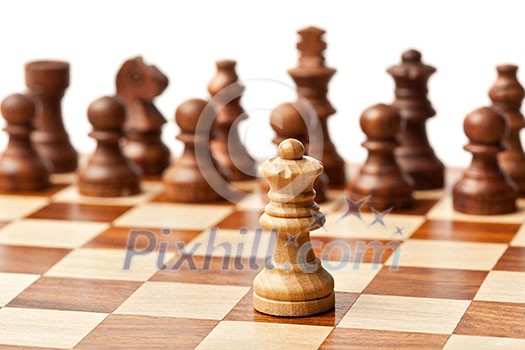 One king agains all - wooden chess pieces on chessboard. Selective focus, shallow depth of field One king agains all - wooden chess pieces on chessboard. Selective focus, shallow depth of field