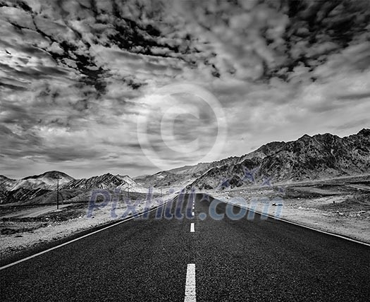 Travel forward concept background - road in Himalayas with mountains and dramatic clouds. Ladakh, Jammu and Kashmir, India. Black and white version Travel forward concept background - road in Himalayas with mountains and dramatic clouds. Ladakh, Jammu and Kashmir, India. Black and white version