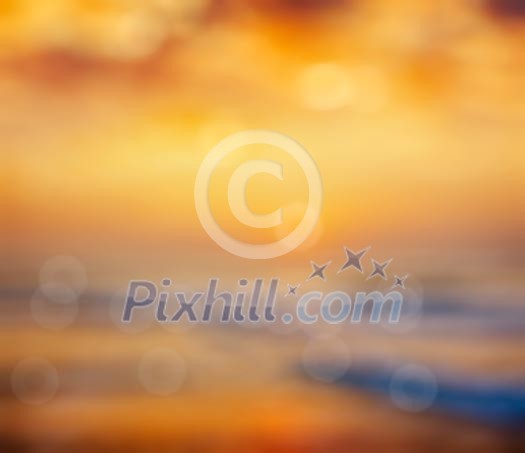 Ocean sunrise on beach defocused background