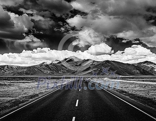 Travel forward concept background - road on plains in Himalayas with mountains and dramatic clouds. Manali-Leh road, Ladakh, Jammu and Kashmir, India. Black and white version Travel forward concept background - road on plains in Himalayas with mountains and dramatic clouds. Manali-Leh road, Ladakh, Jammu and Kashmir, India. Black and white version
