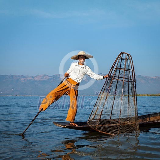 Myanmar travel attraction landmark - Traditional Burmese fisherman at Inle lake, Myanmar famous for their distinctive one legged rowing style Myanmar travel attraction landmark - Traditional Burmese fisherman at Inle lake, Myanmar famous for their distinctive one legged rowing style