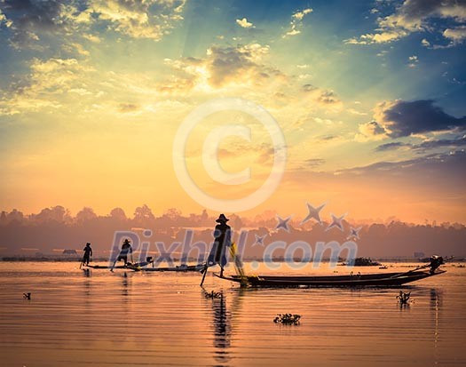 Myanmar travel attraction landmark - traditional Burmese fishermen sihouettes at Inle lake on sunset, Myanmar famous for their distinctive one legged rowing style Myanmar travel attraction landmark - traditional Burmese fishermen sihouettes at Inle lake on sunset, Myanmar famous for their distinctive one legged rowing style