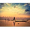 Myanmar travel attraction landmark - traditional Burmese fishermen sihouettes at Inle lake on sunset, Myanmar famous for their distinctive one legged rowing style