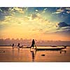 Myanmar travel attraction landmark - traditional Burmese fishermen sihouettes at Inle lake on sunset, Myanmar famous for their distinctive one legged rowing style