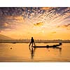 Myanmar travel attraction landmark - traditional Burmese fisherman sihouettes at Inle lake on sunset, Myanmar famous for their distinctive one legged rowing style