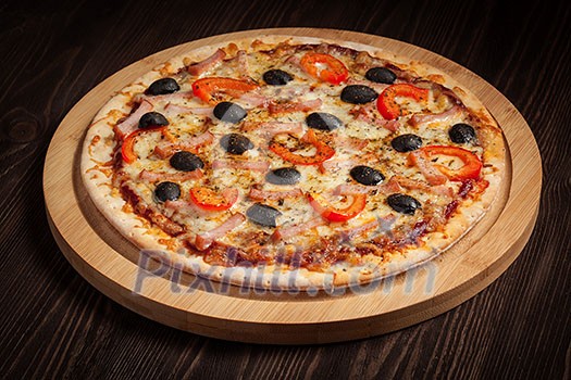 Ham pizza with capsicum and olives on wooden board on table Ham pizza with capsicum and olives on wooden board on table