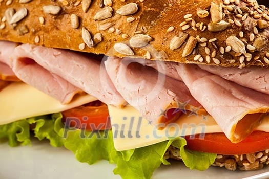 Ham sandwich with lettuce, cheese, tomato close up