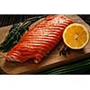 Fresh salmon piece on wooden cooking board with vegetables