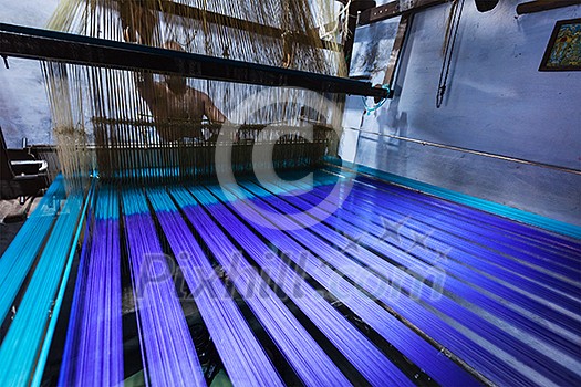 Man weaving silk sari on loom. in Kanchipuram, Tamil Nadu, India. Kanchipuram is famous for hand woven silk sarees and most of the city's workforce is involved in  weaving industry