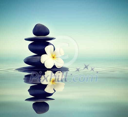 Vintage retro effect filtered hipster style Zen spa concept background - Zen massage stones with frangipani plumeria flower in water reflection