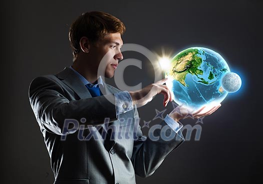Young businessman holding Earth planet in palm. Elements of this image are furnished by NASA Young businessman holding Earth planet in palm. Elements of this image are furnished by NASA