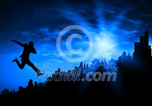 Silhouette of businessman jumping against sunset background