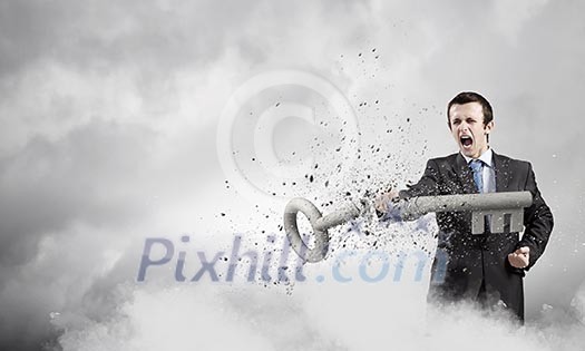 Angry businessman crashing stone key with punch