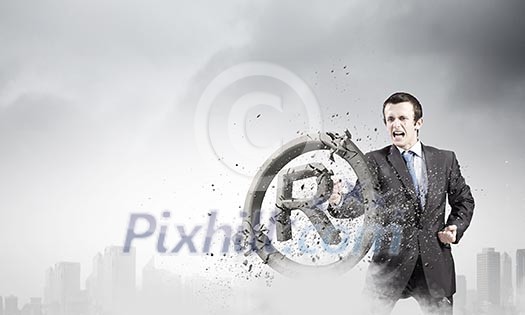 Angry businessman crashing stone trademark with karate punch Angry businessman crashing stone trademark with karate punch