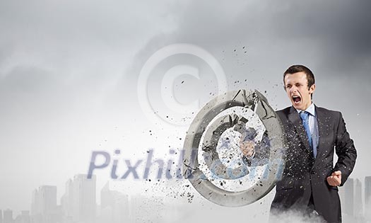 Angry businessman crashing stone trademark with karate punch Angry businessman crashing stone trademark with karate punch