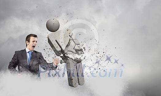 Angry young businessman fighting with stone opponent