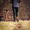 Jogging outdoors in a meadow (shallow dof, focus on the running shoe)