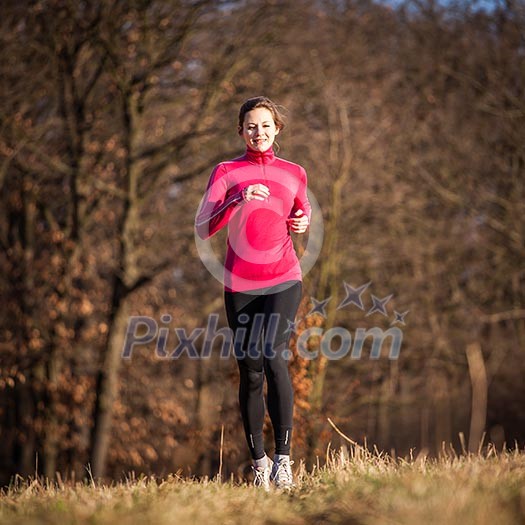 Young woman running outdoors on a lovely sunny winter/fall day